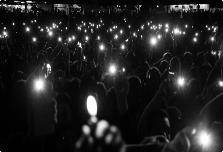 People holding up lighters to the night sky